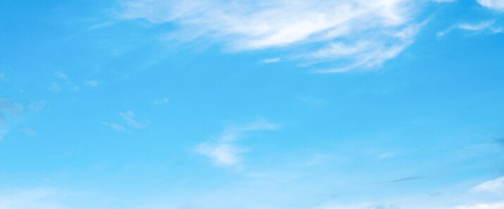 A clear blue sky with wispy white clouds.