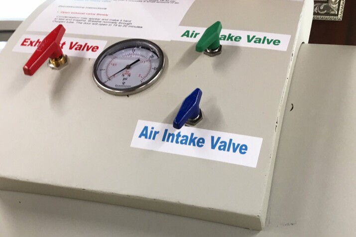 Close-up of an air intake valve with a pressure gauge and control knobs.