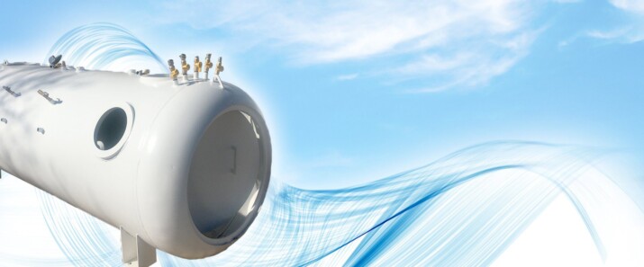 Three small figures stand on a giant clock against a blue sky.