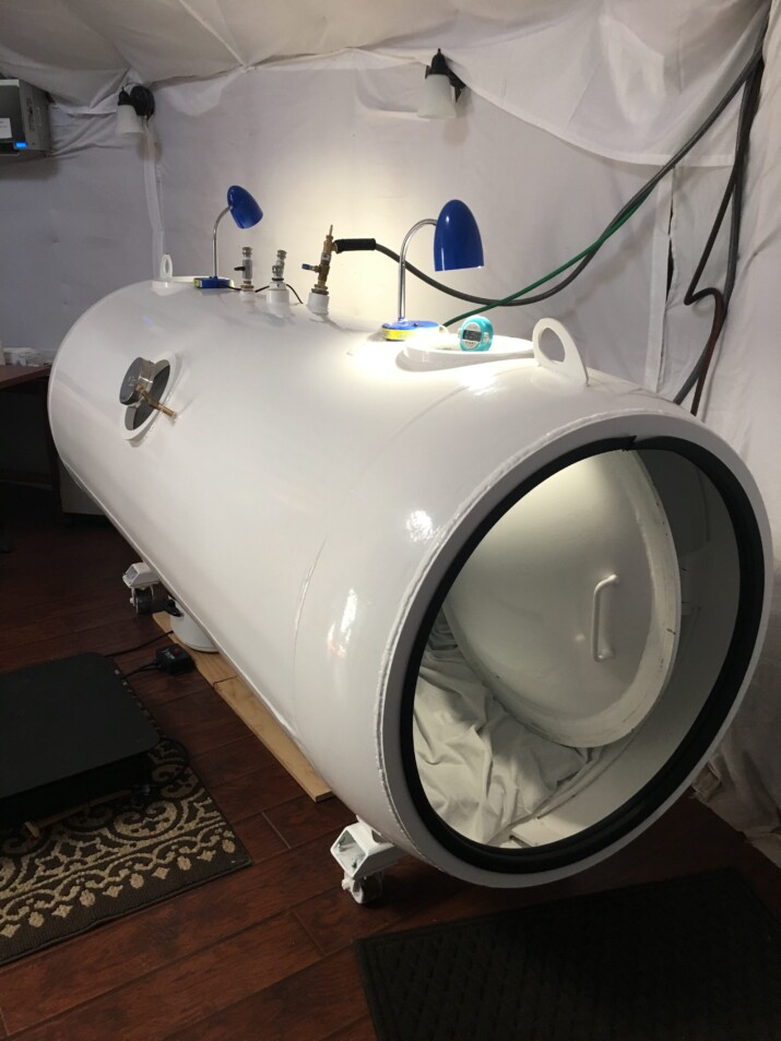 A large white hyperbaric oxygen chamber in a room.