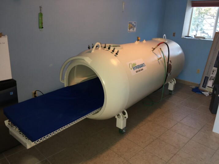 A hyperbaric oxygen therapy chamber in a clinical room.