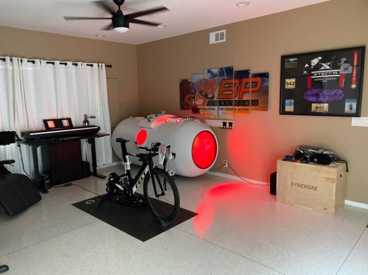 A futuristic gaming setup with a bike mounted inside a glowing tunnel.