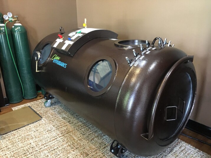 A large black hyperbaric oxygen chamber in a room.